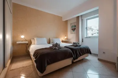 a bedroom with a large bed with a window at Apartamentos Julieta in Albufeira