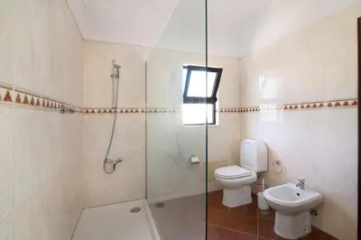 a bathroom with a shower and a toilet and a sink at Casa da Alfarrobeira in Loulé
