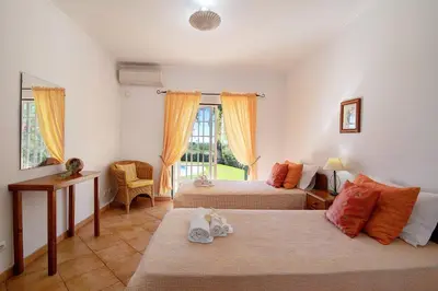 a bedroom with two beds and a window at Casa do Barrocal in Almancil