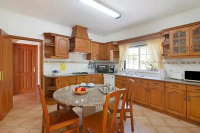 a kitchen with a table and chairs and a kitchen with a table and a kitchen at Casa do Barrocal in Almancil