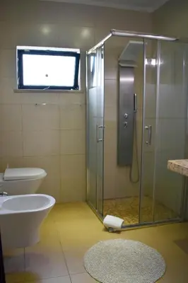 a bathroom with a shower and a toilet and a sink at Vila Castelo in Vale do Lobo
