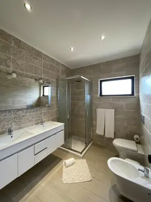 a bathroom with two sinks and a shower and a toilet at Vila Castelo in Vale do Lobo