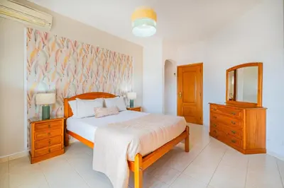 a bedroom with a bed and a dresser and a mirror at Filomena Golf Paradise in Guia