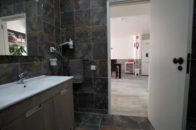 a bathroom with a sink and a mirror at AlbufeiraSun, arrive as a guest leave as a friend. in Albufeira