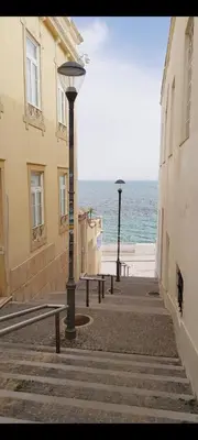 a street with benches and the ocean in the background at AlbufeiraSun, arrive as a guest leave as a friend. in Albufeira