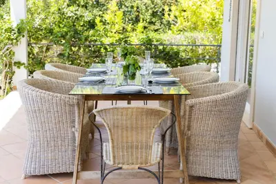 a table with wicker chairs sitting on a patio at Villa Sara in Quarteira