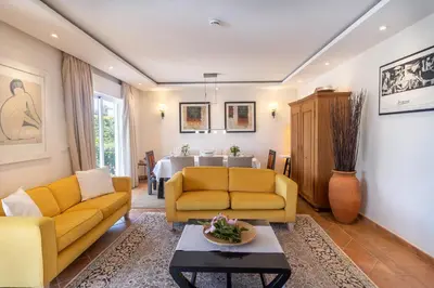 a living room with two yellow couches and a table at Villa Sara in Quarteira