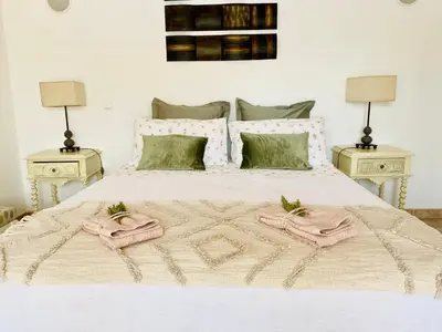 a bedroom with a bed with two tables and two towels at Villa Med - private pool, garden, sun all day, stunning views in Albufeira