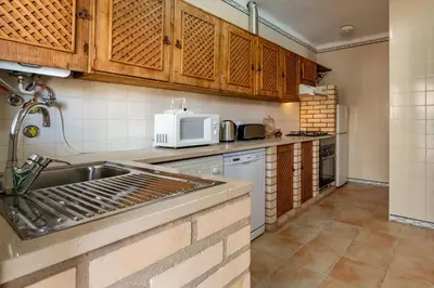a kitchen with a sink and a microwave at Sunny 2BDR House W/ Private Pool by LovelyStay in Albufeira