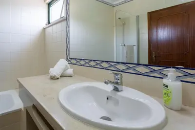 a bathroom with a white sink and a mirror at Sunny 2BDR House W/ Private Pool by LovelyStay in Albufeira