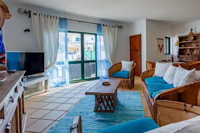 a living room with a couch and a tv at Sunny 2BDR House W/ Private Pool by LovelyStay in Albufeira