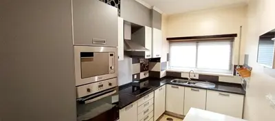a kitchen with white cabinets and a stove top oven at Mshomes II in Albufeira