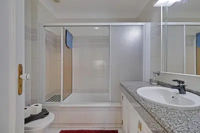 a bathroom with a shower and a sink and a toilet at Vilamoura Main Avenue by Homing in Vilamoura
