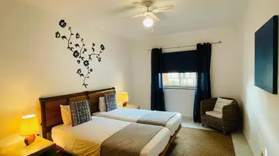 a bedroom with a bed and a fan and a window at Bicos 101 by Check-in Portugal in Albufeira