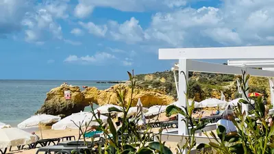 a beach with white umbrellas and the ocean at Bicos 101 by Check-in Portugal in Albufeira