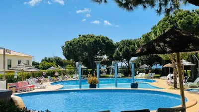 a pool at a resort with chairs and umbrellas at Bicos 303 by Check-in Portugal in Albufeira