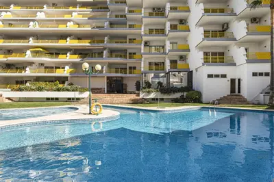 a swimming pool in front of a large apartment building at Alcharb - Modern Studio - Vilamoura center in Vilamoura