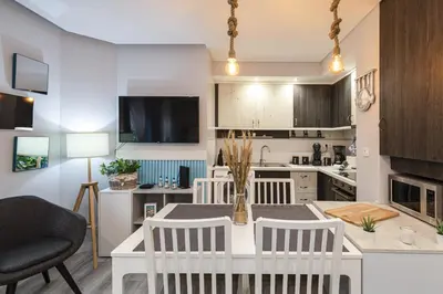 a kitchen with a table and chairs in a room at Alcharb - Modern Studio - Vilamoura center in Vilamoura