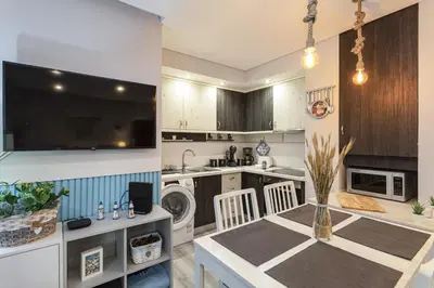 a kitchen and dining room with a table and a tv at Alcharb - Modern Studio - Vilamoura center in Vilamoura