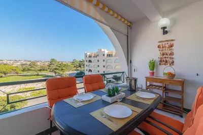 a dining room with a table and chairs and a large window at Albufeira Salgados Beach 1 by Homing in Albufeira