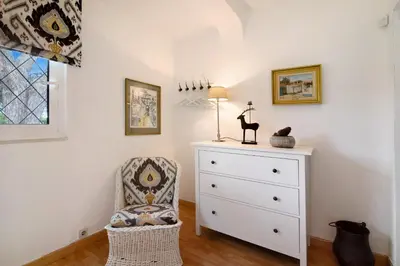 a bedroom with a white dresser and a chair at Casa Las Trinitarias in Vale do Lobo