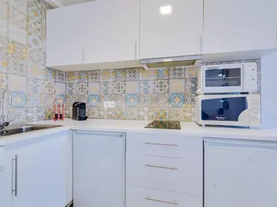 a kitchen with white cabinets and a microwave at AL - Apartamento Sunrise, Sol Nascente 1 Ground floor in Vilamoura