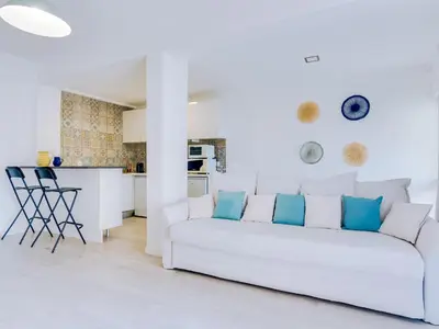 a white living room with a white couch and a kitchen at AL - Apartamento Sunrise, Sol Nascente 1 Ground floor in Vilamoura