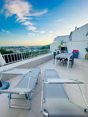 a balcony with tables and chairs on a roof at Ocean View Skyline Apartment ‚Hakuna Matata‘ in Albufeira