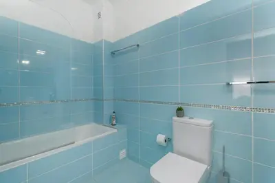 a blue bathroom with a toilet and a bath tub at Typical Fisherman's Cottage with amazing sea views! in Albufeira