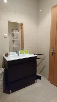 a bathroom with a sink and a mirror and a tub at Faro City Center Apartment I in Faro
