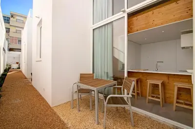 a table and chairs on a patio with a sink at Casa Vermelha I in Faro