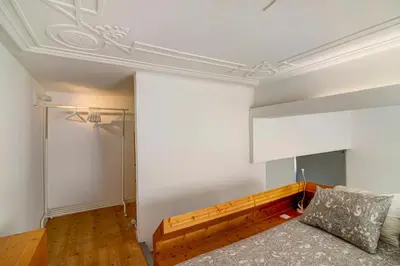 a living room with a couch and a white wall at Casa Vermelha I in Faro
