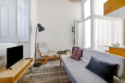a living room with a couch and a television at Casa Vermelha I in Faro