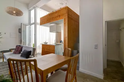 a kitchen and dining room with a wooden table and chairs at Casa Vermelha I in Faro