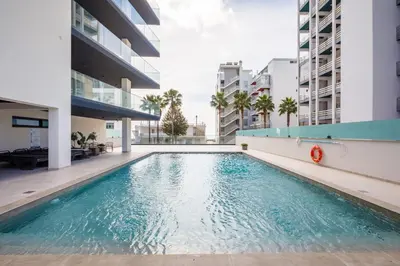 a swimming pool in the middle of a building at Apartamento Porlamar in Quarteira
