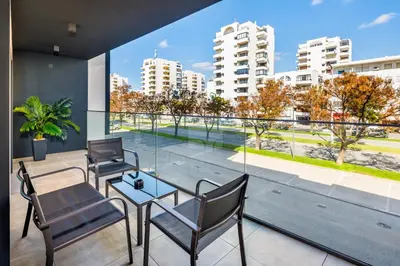 a balcony with chairs and a table and a view of a city at Apartamento Porlamar in Quarteira