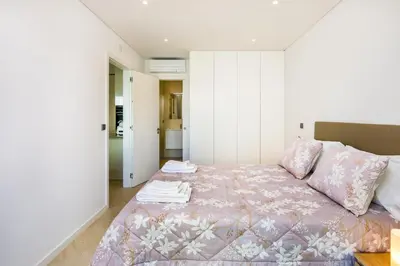 a bedroom with a bed with a pink bedspread at Apartamento Porlamar in Quarteira