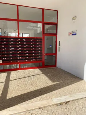 an empty building with a red door and windows at Castelo I in Quarteira