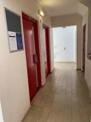 an empty hallway with red doors and a tile floor at Castelo I in Quarteira