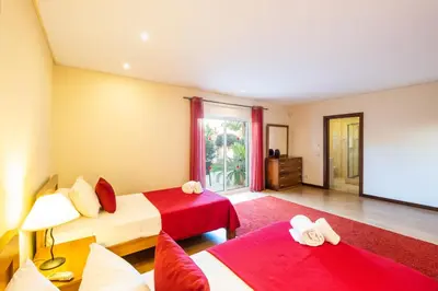 a bedroom with two beds and a red rug at Villa Cordeiro - Heated Pool - Free wi-fi - Air Con in Guia