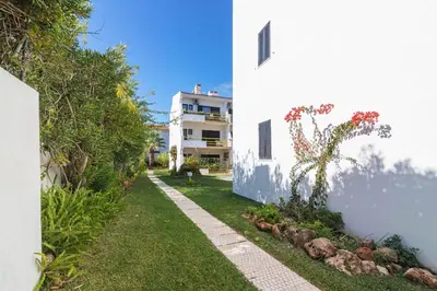 a garden next to a white building with a plant at Vilamoura Premium Apartment With Pool by Homing in Vilamoura