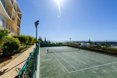 a bedroom with a white bed and a large window at BnB Homes Ocean view Apartment with huge sunny Terrace, 2 Swimming pools & Tennis court in Albufeira