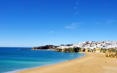 a row of lounge chairs next to a swimming pool at BnB Homes Ocean view Apartment with huge sunny Terrace, 2 Swimming pools & Tennis court in Albufeira