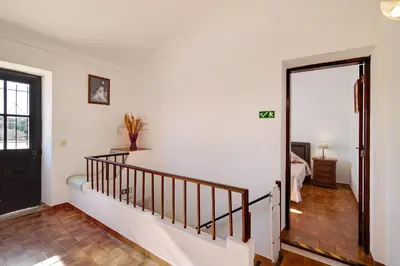 a hallway with a stairway leading to a bedroom at Vila Caracol in Guia