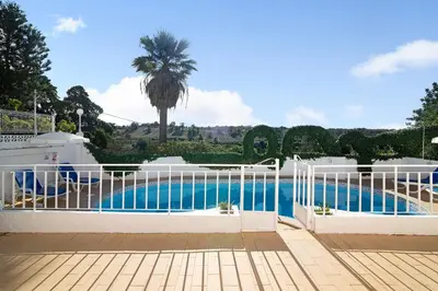 a balcony with a table and a swimming pool at Vila Caracol in Guia