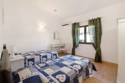 a bedroom with a bed and a desk and a window at Vila Filipa in Guia