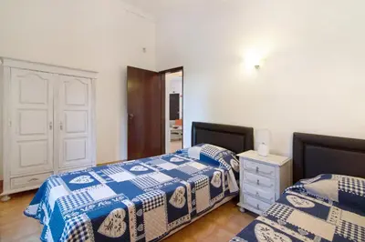 a bedroom with two beds and a dresser and a mirror at Vila Filipa in Guia