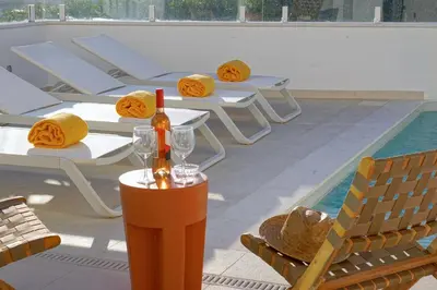 a group of tables and chairs next to a swimming pool at Casa do Pátio-Two Private Pools Villa- Rooftop & Panoramic Pool by DreamvillasAlbufeira in Albufeira