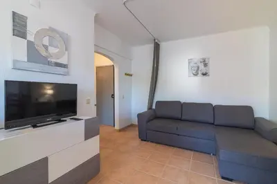 a living room with a couch and a flat screen tv at Vilamoura Cosy 2 with Pool by Homing in Vilamoura