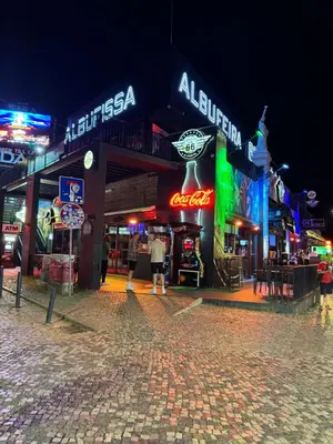 a street at night with many neon signs at The Strip Oura apartment in Albufeira